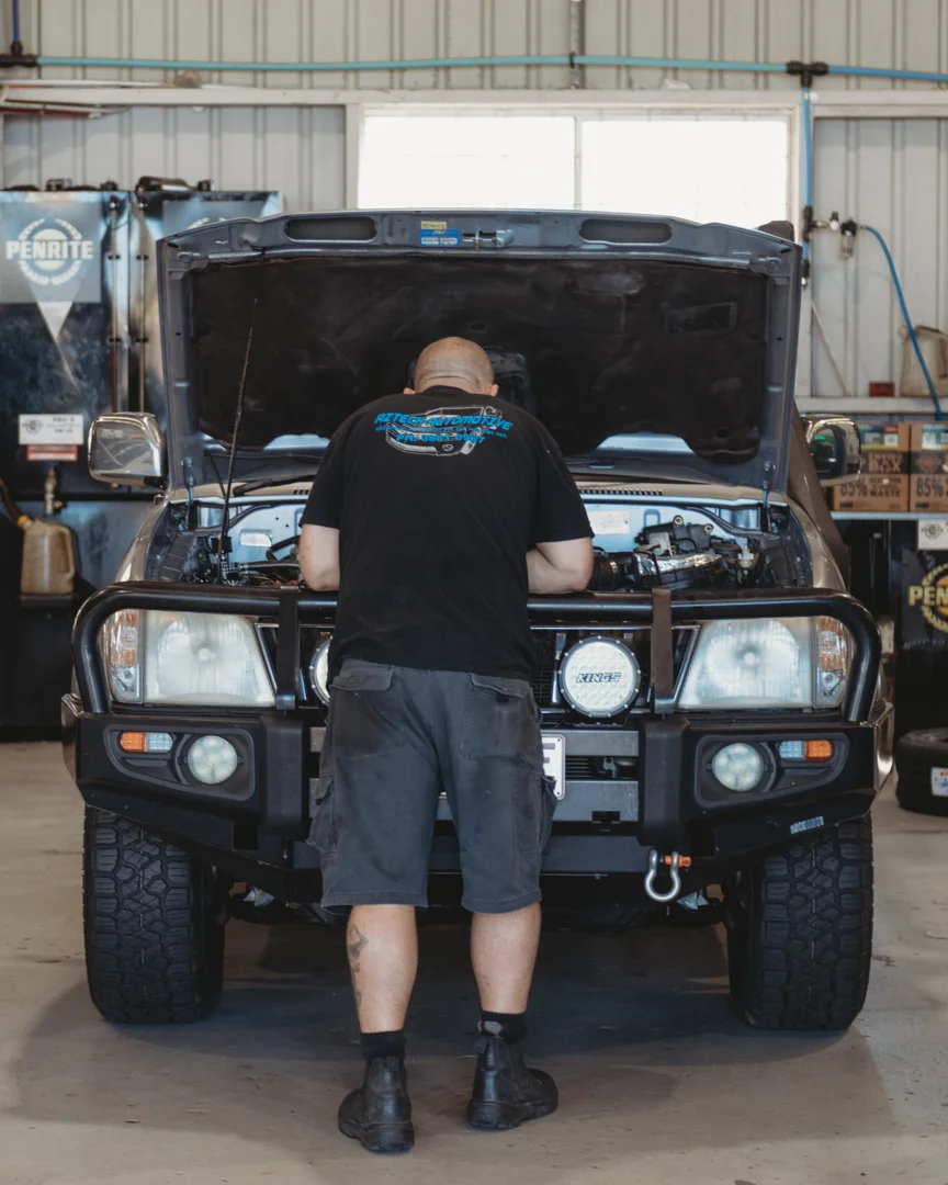 Mechanic working on the front of a four wheel drive