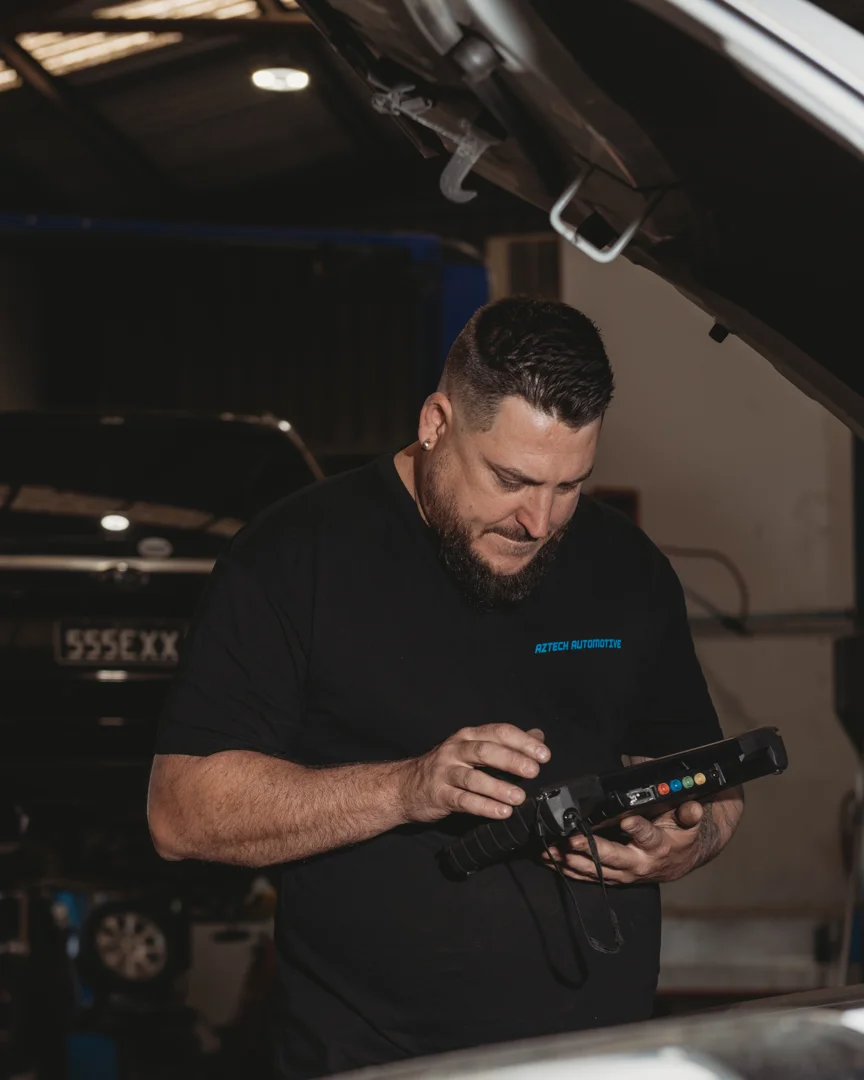 Mechanic carrying out engine-bay diagnostics at Aztech Automotive